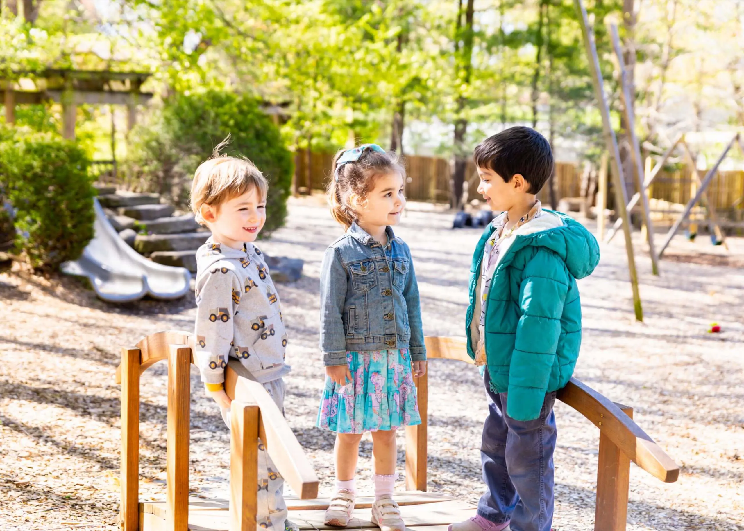 Three MSNV students standing together outdoors on a sunny day near the school grounds.
