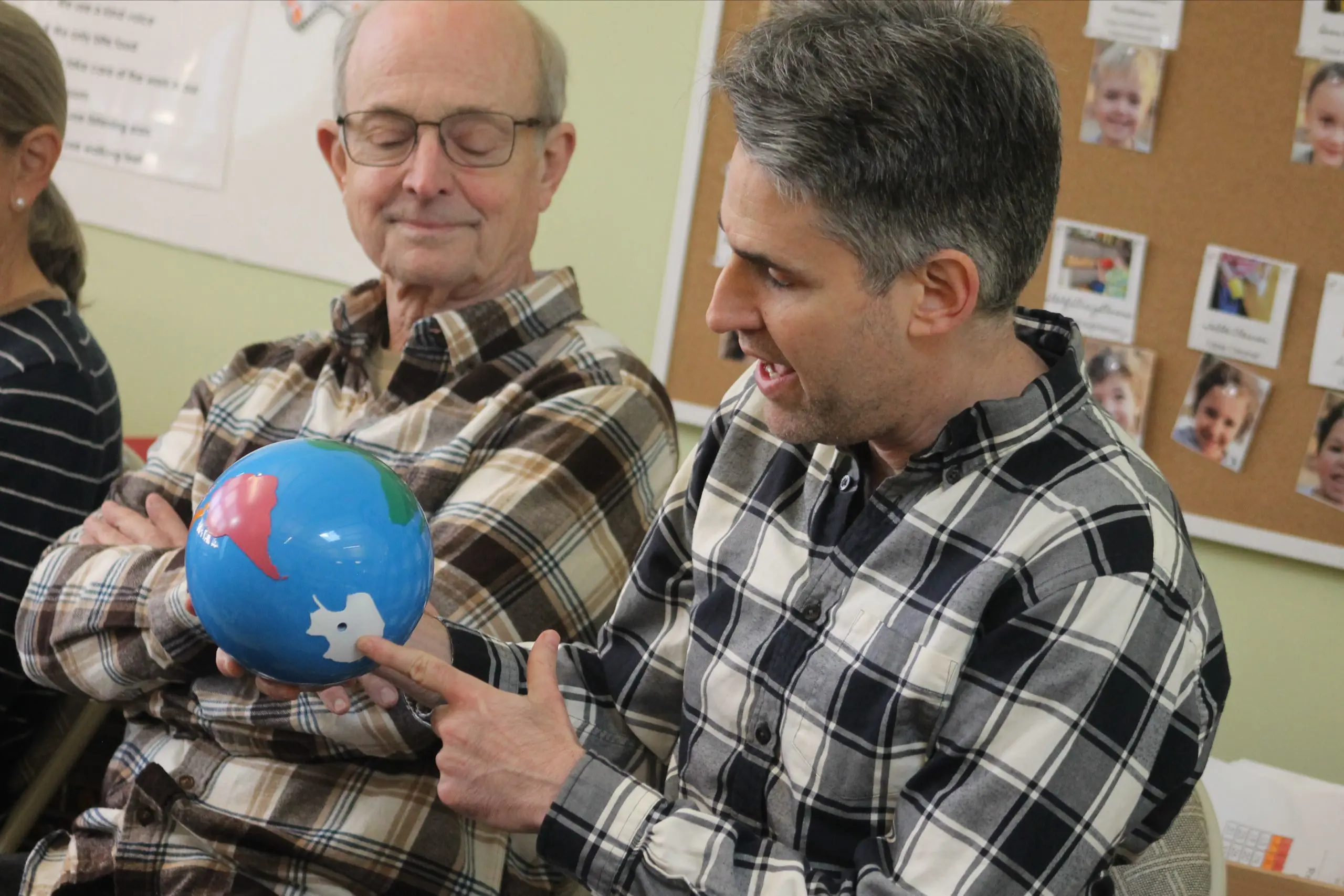 A father and child looking at a globe together during an MSNV classroom or community event.