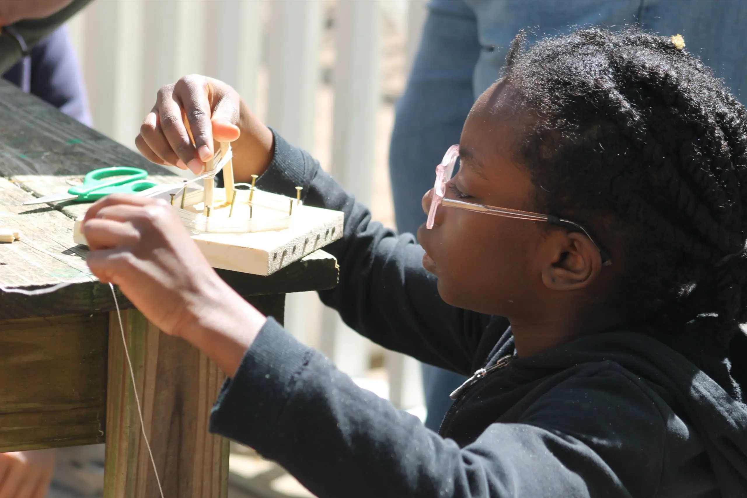 An MSNV student focused on a hands-on learning activity outdoors.