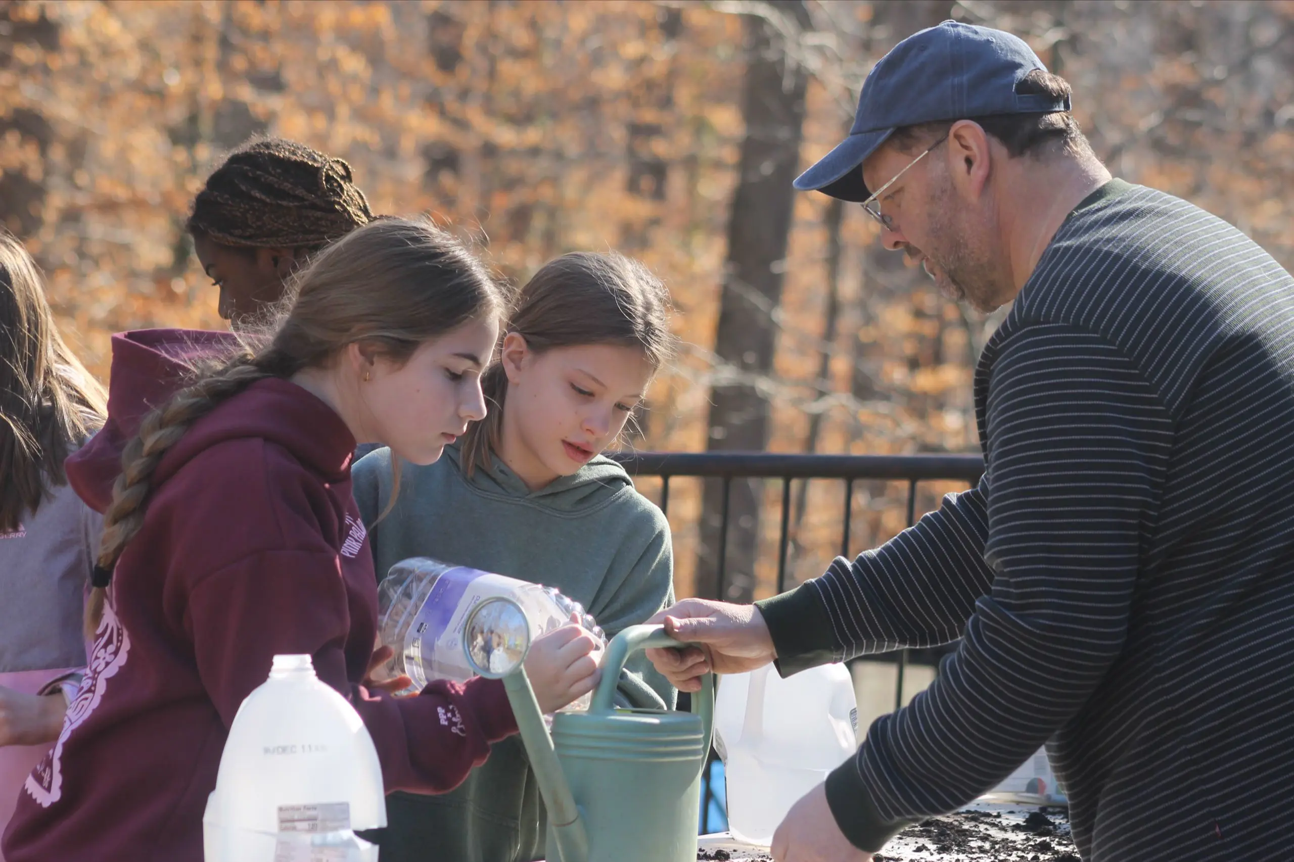 An MSNV teacher and upper elementary students working together in the school garden.