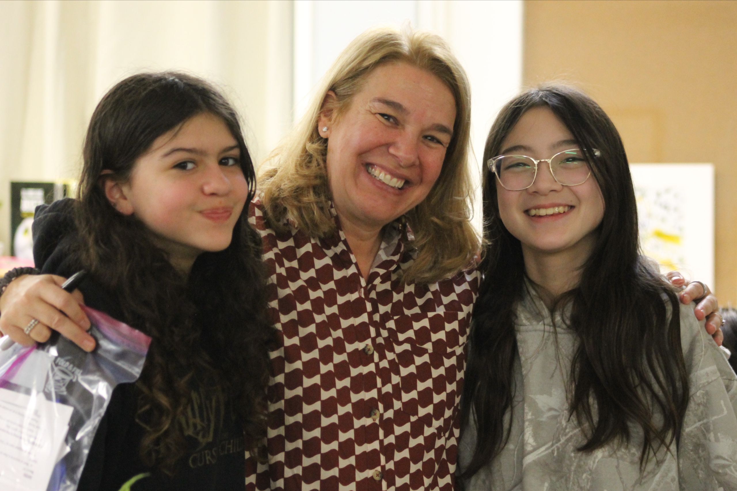 MSNV Head of School smiling with two middle school students at a school event.