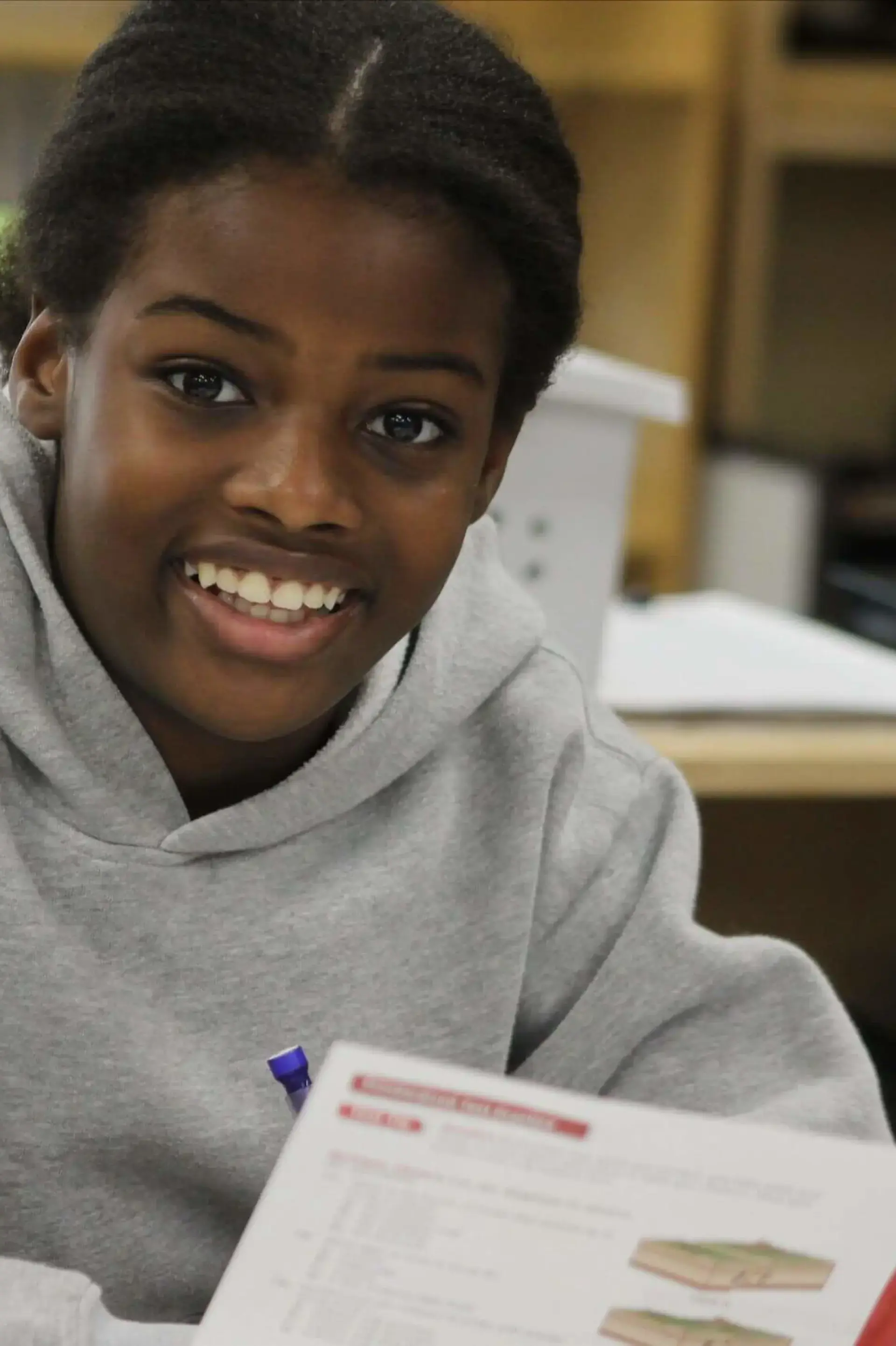 Student looking happily up from textbook